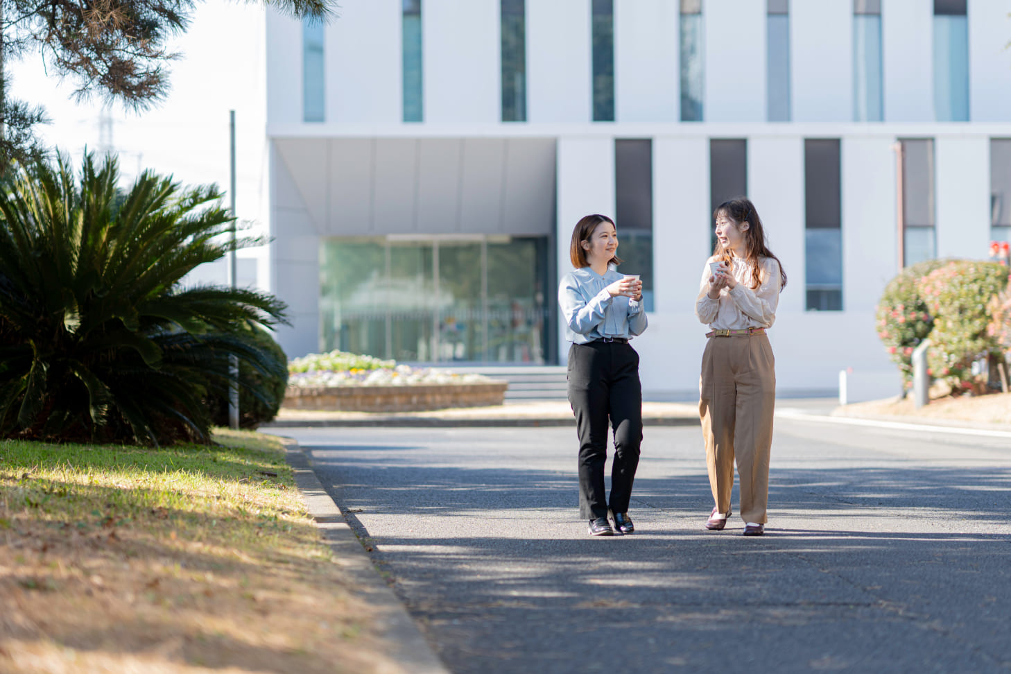笑顔で歩くスタッフとオフィス外観